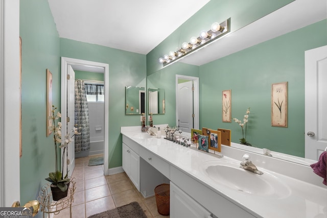 full bathroom featuring double vanity, baseboards, a sink, and tile patterned flooring