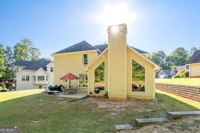 back of property featuring a patio, a yard, and a chimney