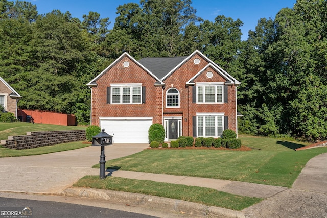 view of front facade with a garage, concrete driveway, a front yard, and brick siding