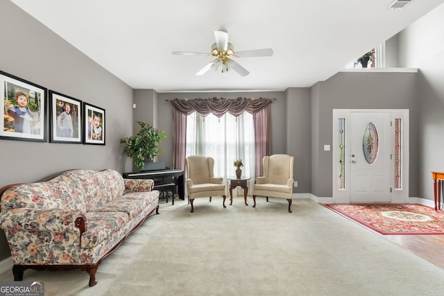 living area with baseboards, ceiling fan, and carpet floors
