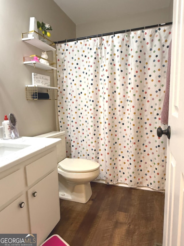 full bathroom with toilet, curtained shower, wood finished floors, and vanity