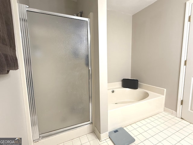 full bathroom featuring tile patterned floors, baseboards, a shower stall, and a bath