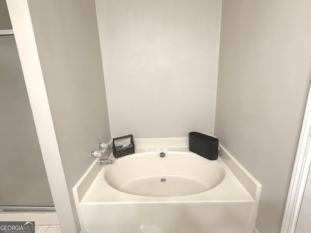 bathroom featuring tile patterned floors and a bath