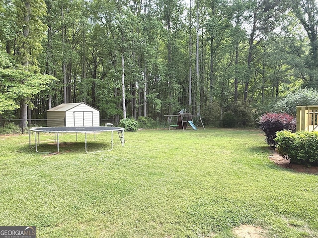 view of yard featuring a storage shed, fence, an outdoor structure, and a playground