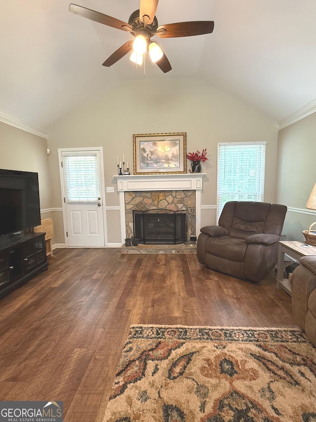 living area with a ceiling fan, wood finished floors, vaulted ceiling, and a fireplace
