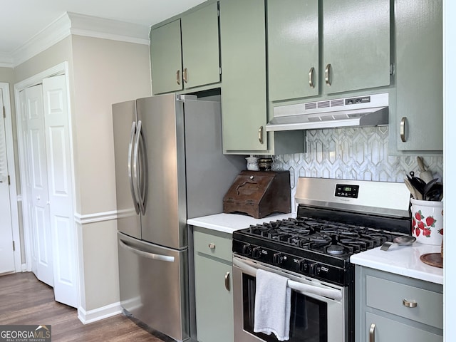 kitchen featuring crown molding, appliances with stainless steel finishes, dark wood finished floors, green cabinets, and under cabinet range hood