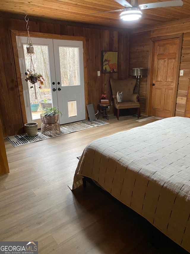 bedroom with access to outside, wood walls, and wooden ceiling