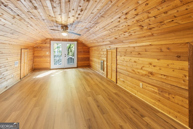 bonus room with light wood-style floors, a ceiling fan, visible vents, wooden ceiling, and wooden walls