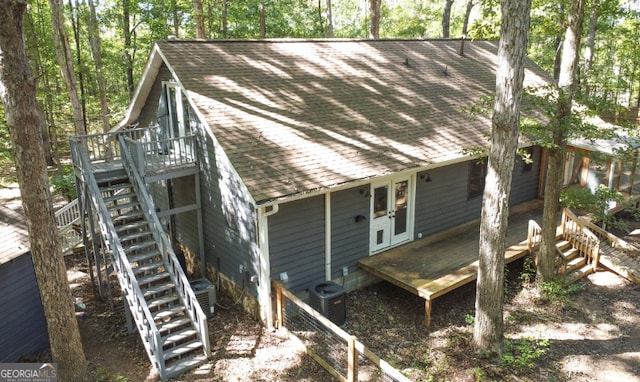 exterior space with roof with shingles, a deck, stairway, cooling unit, and french doors