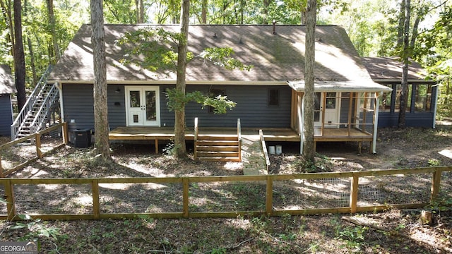 rear view of house featuring french doors, a deck, a sunroom, and stairway