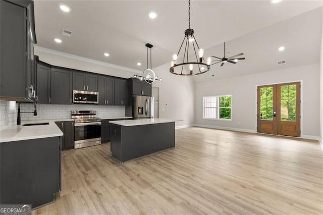 346 Chandler Ct, Alto, GA 30510 - kitchen with a notable chandelier, light wood-style flooring, a center island, stainless steel appliances, and decorative backsplash