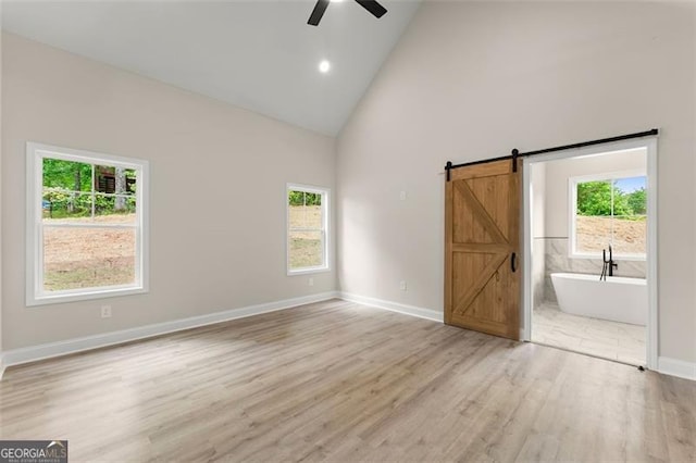 346 Chandler Ct, Alto, GA 30510 - spare room featuring a ceiling fan, light wood-type flooring, a barn door, high vaulted ceiling, and baseboards