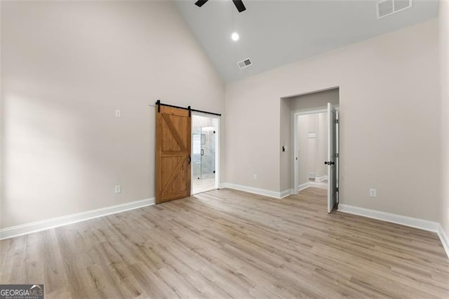 346 Chandler Ct, Alto, GA 30510 - unfurnished bedroom featuring high vaulted ceiling, light wood-style flooring, a barn door, and visible vents