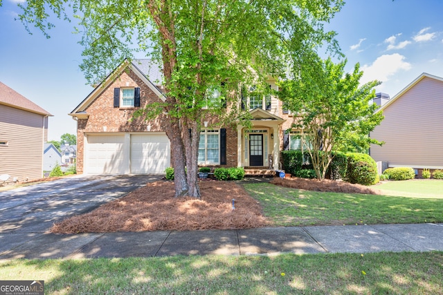 1584 Heartland Path, Hoschton, GA 30548 - view of front of house with driveway, brick siding, a front yard, and an attached garage