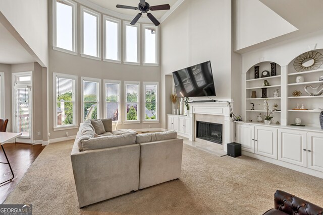 1584 Heartland Path, Hoschton, GA 30548 - living area featuring carpet flooring, a premium fireplace, a ceiling fan, a high ceiling, and built in features