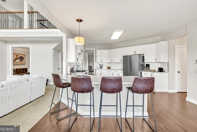 1584 Heartland Path, Hoschton, GA 30548 - kitchen with freestanding refrigerator, a breakfast bar area, light countertops, and a peninsula