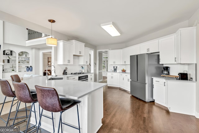 kitchen featuring a sink, stainless steel appliances, light countertops, and tasteful backsplash