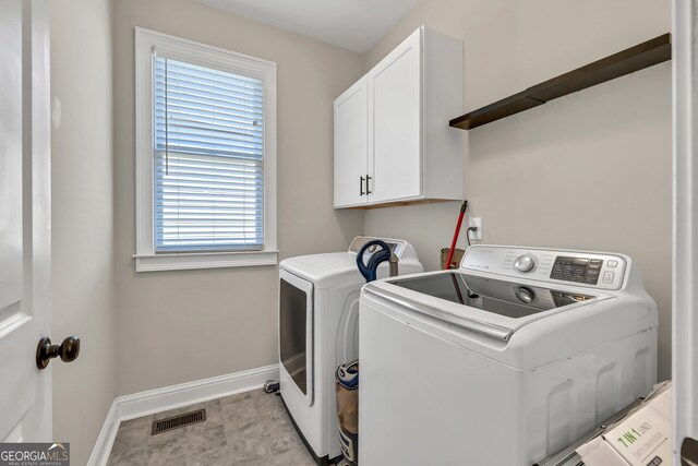 laundry area with baseboards, washing machine and dryer, and cabinet space