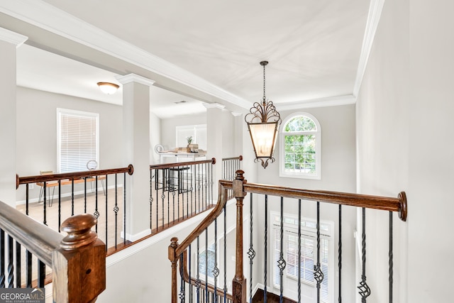 hall with an upstairs landing, ornamental molding, a chandelier, and baseboards