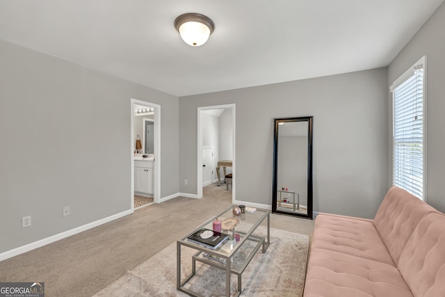 living room featuring light colored carpet and baseboards
