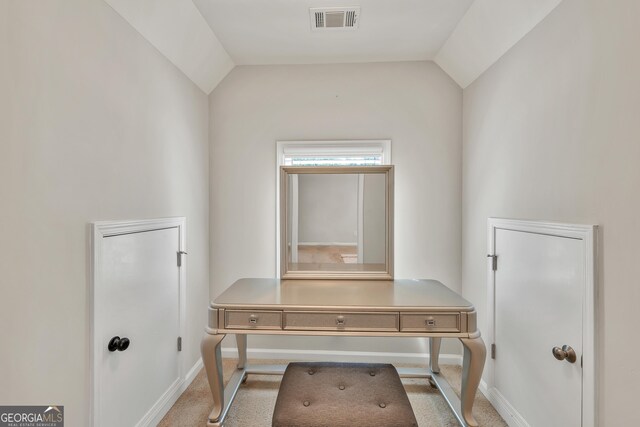 hallway with baseboards, lofted ceiling, and carpet