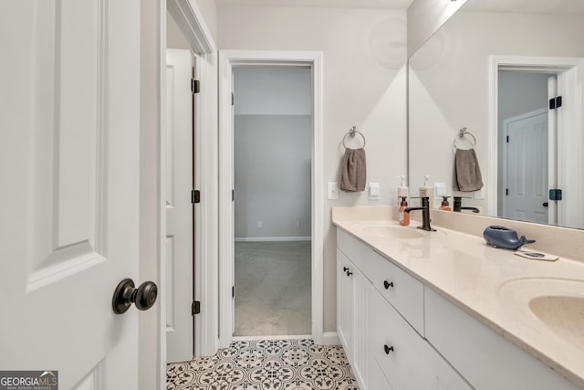 bathroom featuring double vanity, tile patterned flooring, and baseboards