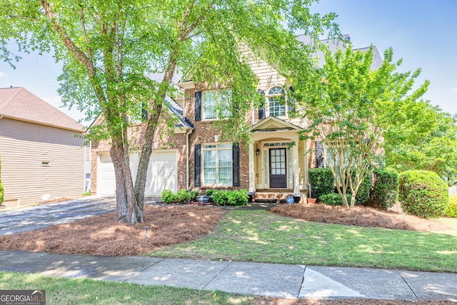 view of front of property with driveway, brick siding, a front lawn, and an attached garage