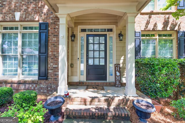 1584 Heartland Path, Hoschton, GA 30548 - doorway to property with brick siding and a porch