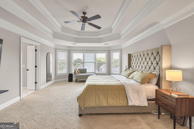 bedroom featuring a tray ceiling, carpet floors, crown molding, ceiling fan, and baseboards