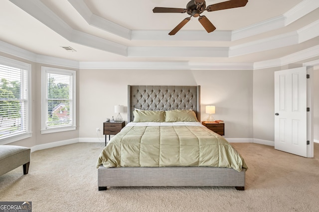 carpeted bedroom featuring a raised ceiling, ornamental molding, baseboards, and ceiling fan