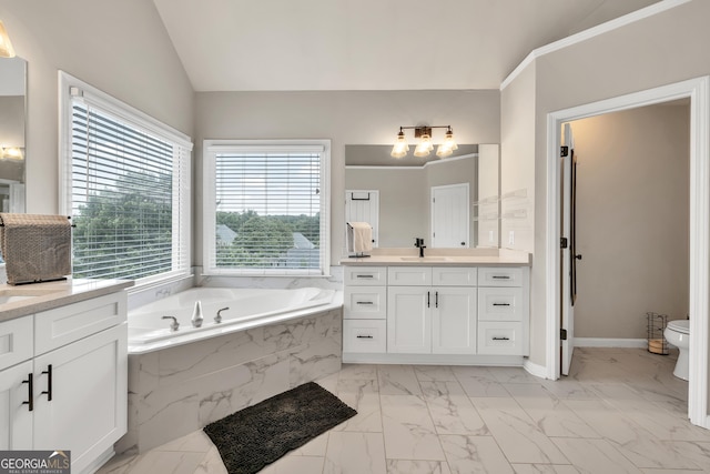full bath with marble finish flooring, vaulted ceiling, toilet, two vanities, and a bath