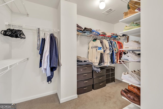 walk in closet with light colored carpet