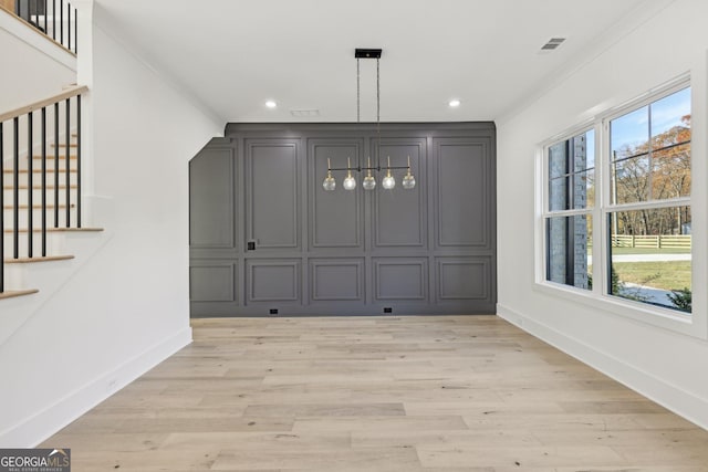 unfurnished dining area with baseboards, visible vents, and light wood finished floors