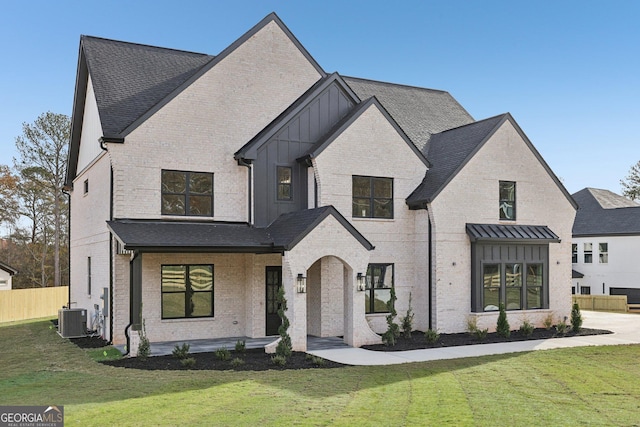 modern farmhouse with board and batten siding, brick siding, cooling unit, and a front yard