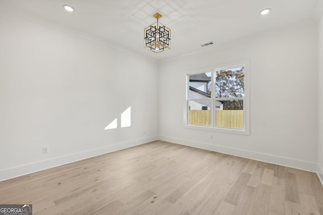 spare room featuring baseboards, light wood finished floors, and visible vents