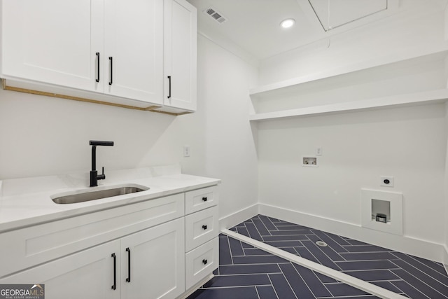 clothes washing area featuring visible vents, hookup for a washing machine, electric dryer hookup, a sink, and cabinet space