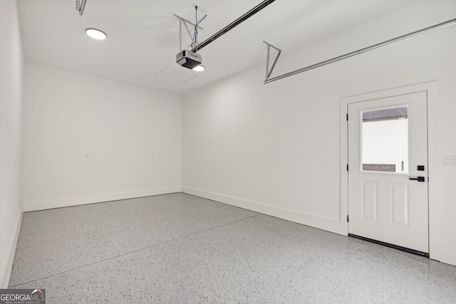 garage with baseboards and a garage door opener