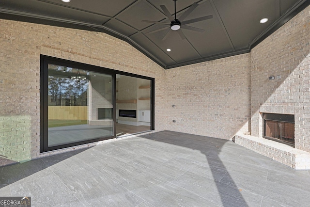 view of patio featuring a ceiling fan and an outdoor brick fireplace