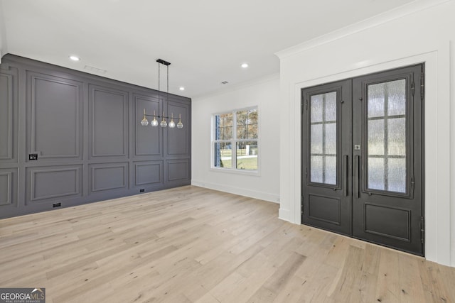 foyer with crown molding, french doors, baseboards, and light wood-style flooring