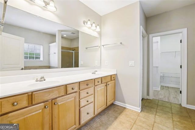 7712 Soaring Eagle Dr, Flowery Branch, GA 30542 - full bath featuring a stall shower, double vanity, a spacious closet, and tile patterned floors