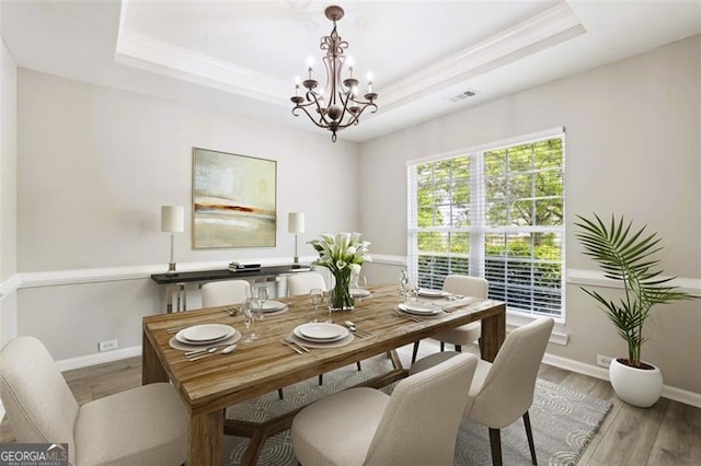 7712 Soaring Eagle Dr, Flowery Branch, GA 30542 - dining space featuring a tray ceiling, a chandelier, wood finished floors, and ornamental molding
