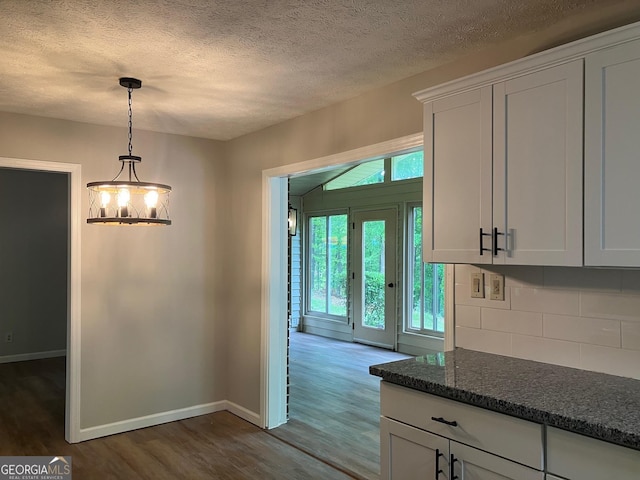 kitchen with a textured ceiling, tasteful backsplash, baseboards, white cabinetry, and dark wood-type flooring