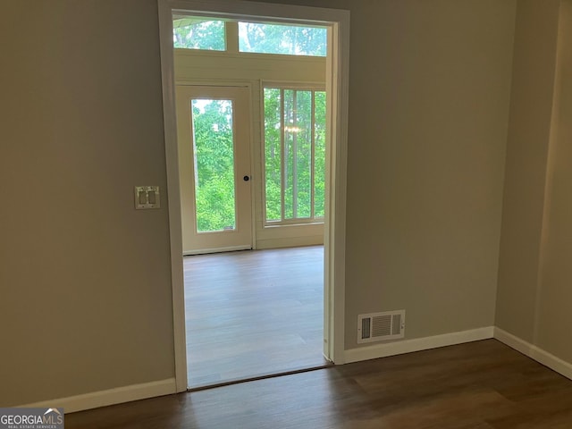 entryway with baseboards, visible vents, and dark wood finished floors