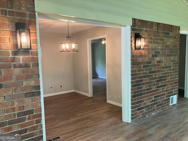 interior space with baseboards, a ceiling fan, wood finished floors, and visible vents