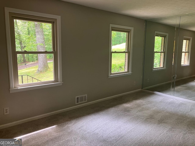 unfurnished bedroom with visible vents, carpet, and baseboards