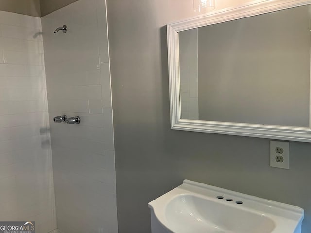 full bathroom with a sink and tiled shower