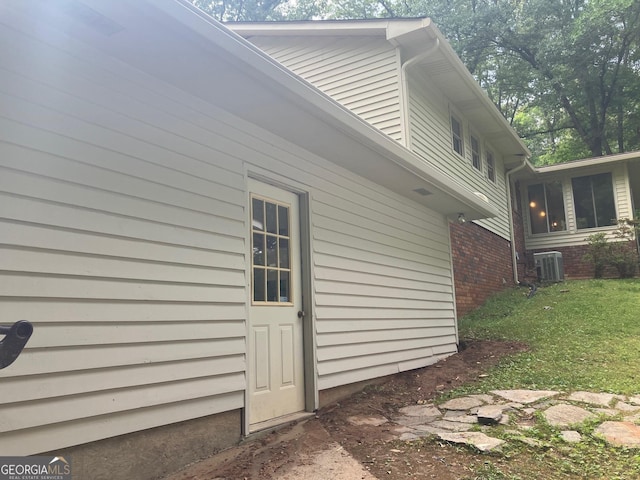 view of side of property with central AC unit and brick siding