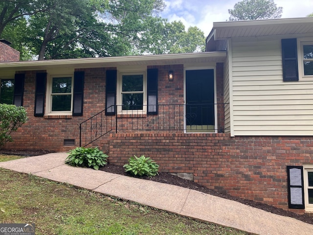 view of home's exterior with brick siding and crawl space