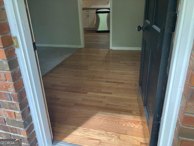 hallway featuring baseboards and light wood-style flooring