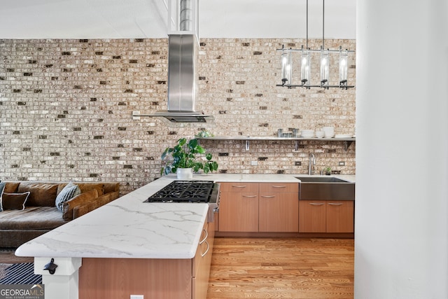 3820 Roswell Rd NE Unit 705, Atlanta, GA 30342 - kitchen featuring a sink, wall chimney exhaust hood, light wood-type flooring, open floor plan, and light stone counters